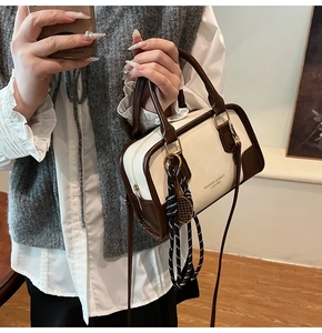 Detailed shot of color-block tote bag with PU leather texture and tennis racket charm