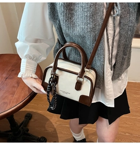 Close-up of a retro contrast color handbag with leather texture and metal zipper details