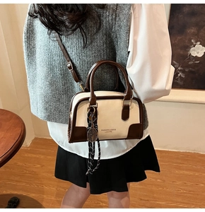 Detail of color-block Boston bag with tennis racket charm and adjustable shoulder strap