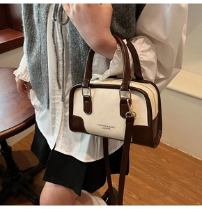 Detailed view of the bicolor Boston handbag styled with a minimalist commuter outfit
