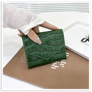 Primer plano de la textura de piel de cocodrilo verde oscuro en un bolso sobre corto