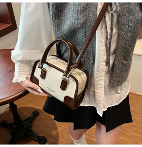 Detail of a contrast color Boston bag with double handles and logo print detail
