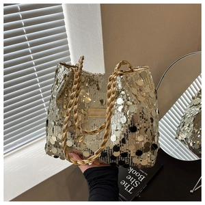 Close-up of golden sequin tote bag with woven handles and fashion logo patch
