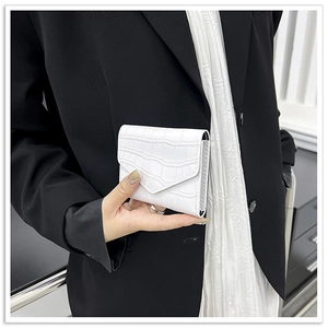 Close-up of white crocodile texture card holder held against a black blazer background