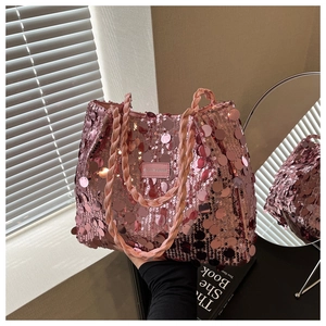 Detail of pink sequin tote bag showing woven handles and fashion leather logo plate