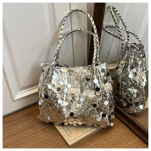Macro shot of silver sequin tote bag showing detailed metallic texture and woven handles