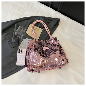 Close-up of pink sequin handbag with woven knot handle and fashion brand tag