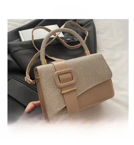 Detail of apricot crossbody bag showing beige woven texture and large square buckle accent