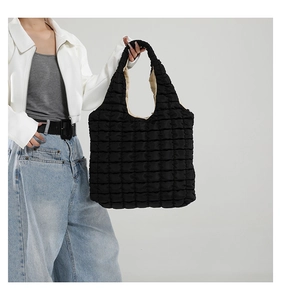 Detail of black quilted puffy tote bag featuring textured 3D grid and spacious interior