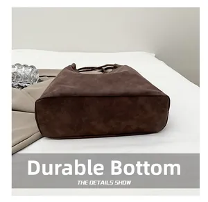 Vue détaillée du fond renforcé résistant à l'usure de ce grand sac fourre-tout marron
