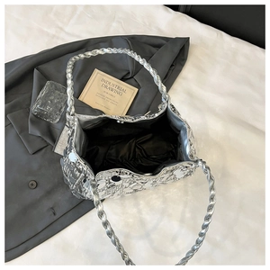 Detail view of large silver sequin bag showing black lining and metal magnetic closure