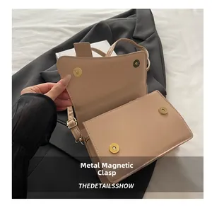 Detail view of the apricot saddle bag showing dual gold magnetic snap buttons on interior