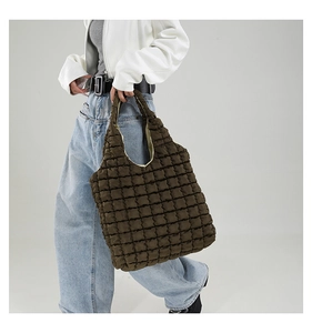 Detailed close-up showing the premium quilted texture of the dark brown tote bag