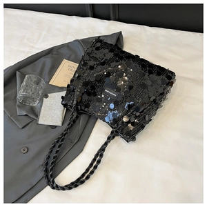 Close-up of black sequined shoulder bag featuring a woven handle and fashion label tag