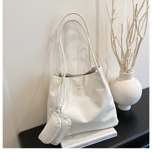 Vue détaillée d'un sac cabas en cuir blanc avec sa pochette zippée assortie et logo gris