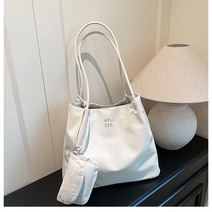 Détail du sac polochon en tissu Oxford blanc avec logo HYLL ZZA et mini porte-monnaie