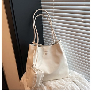 Gros plan du sac cabas blanc en cuir avec pochette amovible et lettrage HYLL ZZA