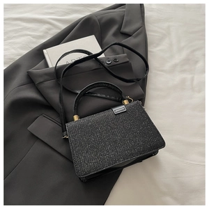 Vue de dessus d'un sac à main carré à paillettes noires avec détails dorés et bandoulière