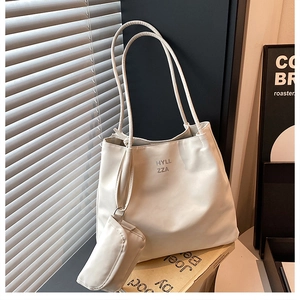 Gros plan d'un sac cabas en tissu Oxford beige avec une petite pochette assortie et lettrage noir