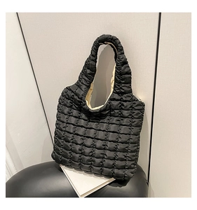 Detail der schwarzen gesteppten Puffer-Tasche mit Bubble-Textur und beigem Futter