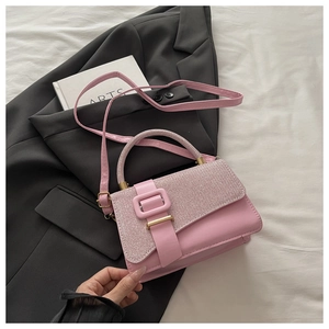 Vue détaillée du sac rose en cuir texturé avec boucle métallique et poignée fine