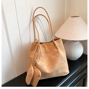 Détail du sac polochon en tissu Oxford camel avec mini pochette assortie et logo gravé