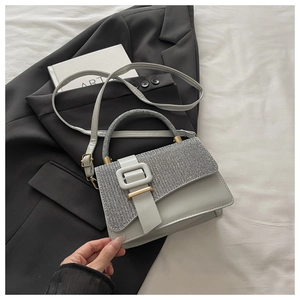 Détail du rabat pailleté argenté et de la boucle en métal d'un sac bandoulière rétro