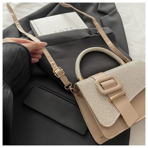 Détail du sac bandoulière abricot avec poignée scintillante et grande boucle carrée chic