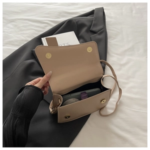 Vue intérieure du sac bandoulière beige montrant l'espace pour téléphone et maquillage