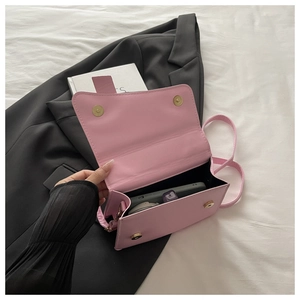 Vue détaillée du sac carré rose montrant les boutons aimantés et l'intérieur