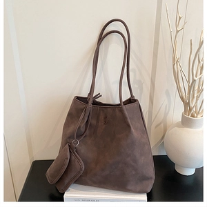 Détail du grand sac cabas en daim marron foncé avec pochette et logo en relief