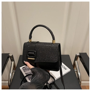 Gros plan du sac à paillettes noir montrant la texture brillante et la boucle en métal