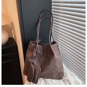 Détail d'un cabas marron mat avec logo embossé et mini pochette amovible assortie