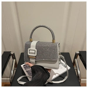 Détail du mini sac blanc avec surface en strass étincelants et boucle décorative blanche