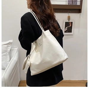 Grand sac cabas blanc en cuir souple avec imprimé porté par un mannequin pour taille