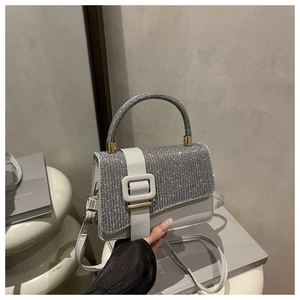 Détail du sac à main élégant en strass gris avec lanière en cuir blanc et boucle carrée