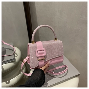 Gros plan du sac rose avec rabat orné de strass brillants et boucles en métal doré