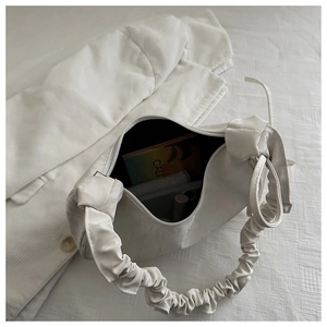 Detailed interior view showing large capacity of the white pleated dumpling bag with items