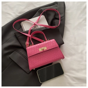 Détail du mini sac rose fuchsia avec texture croco, fermoir doré et bandoulière