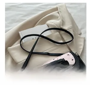 Détails du sac bandoulière rose gaufré avec nœud noir et pendentif cœur en argent