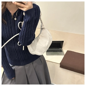 Detail of white wrinkled hobo bag carried by a model in a minimalist lifestyle setting