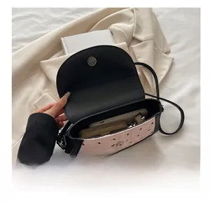 Vue de dessus du sac bandoulière rose à motifs montrant l'intérieur spacieux et le fermoir
