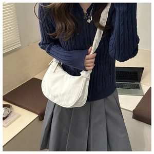 Detailed texture of a white crescent shoulder bag with pleated nylon fabric and logo