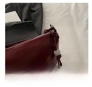 Detailed shot of dark wine red leather tote with silver zipper and beaded drawstring