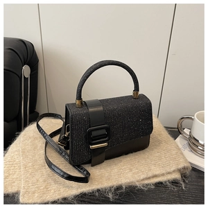 Détail du tissu pailleté et contraste cuir noir sur un sac bandoulière carré vintage