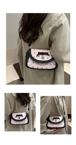 Vue détaillée du sac rose avec imprimé nœuds, pendentif cœur et texture froissée