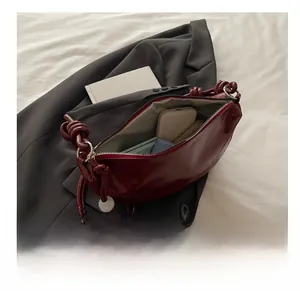 Top view of deep red dumpling bag showing large capacity for phone and wallet items