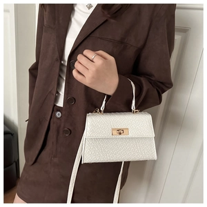 Vue détaillée du sac en cuir tressé blanc avec fermoir tournant doré et bandoulière