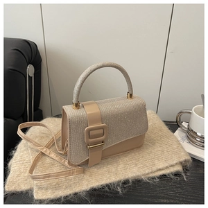 Détail du sac carré champagne scintillant sur une écharpe montrant les textures