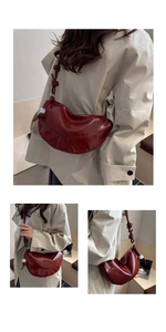 Detail of burgundy crescent bag featuring unique knot strap and white sphere charms